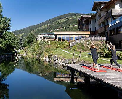 zwei Frauen beim Yoga beim Naturbadeteich im Sporthotel Sillian in Osttirol