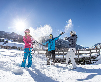 Skiurlauber schmeißen Schnee in die Luft im Skiurlaub beim Sporthotel Sillian im Hochpustertal