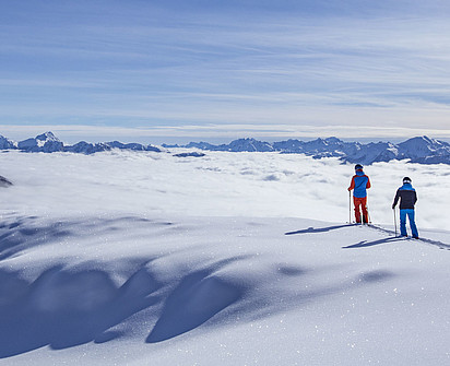 zwei Skifahrer über den Wolken auf den Bergen Osttirol beim Sporthotel Sillian 